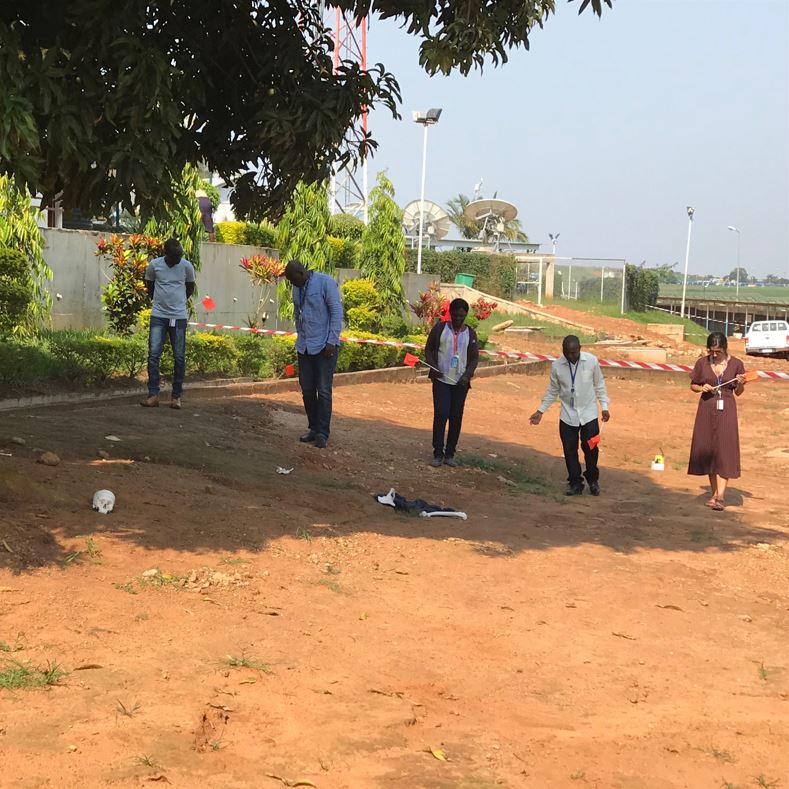 trainees prepare to sweep a large outdoor area for evidence