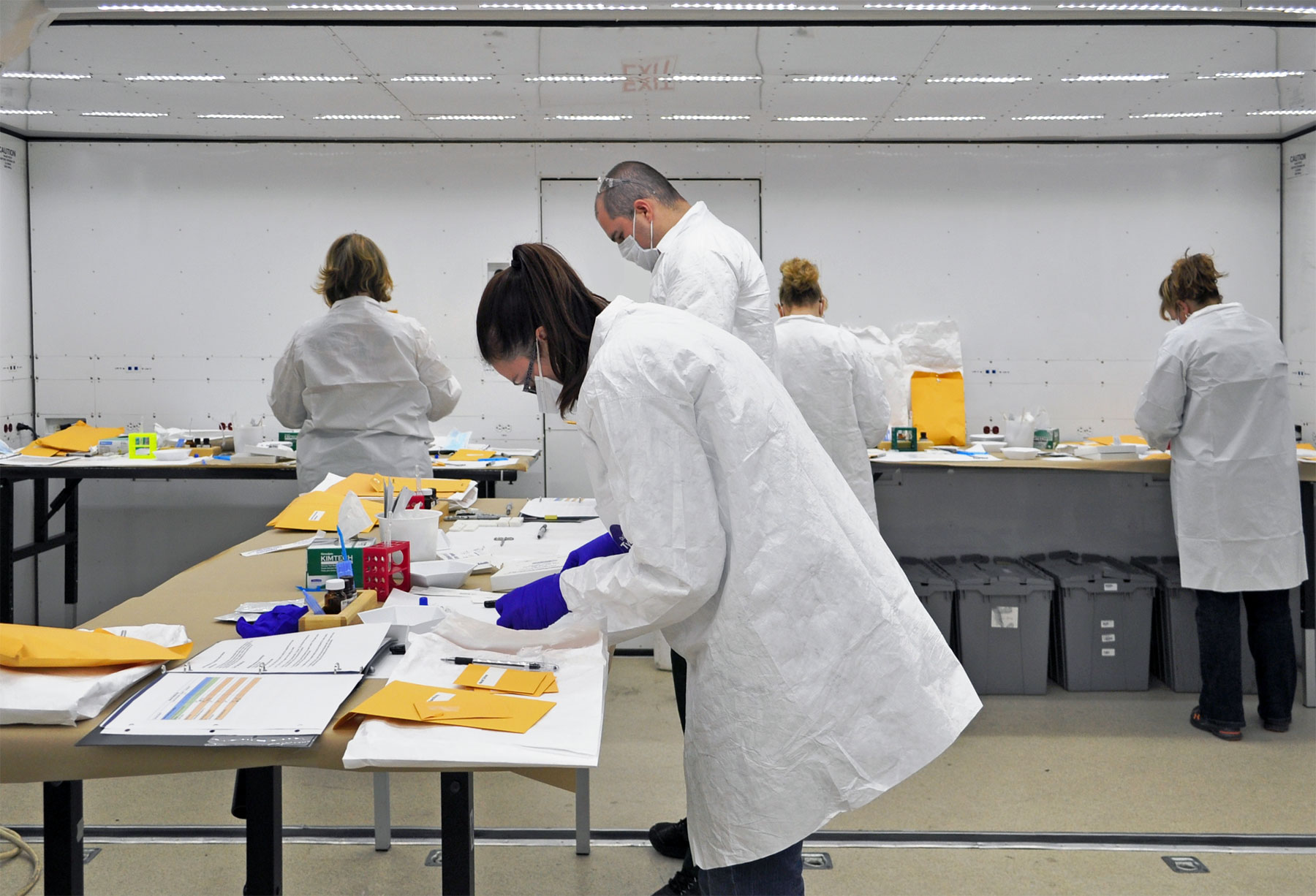 Interior of a working laboratory with 4 analysts conducting bioscreening tests.