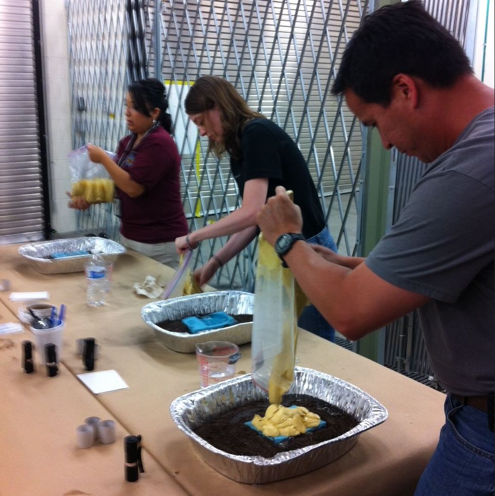 3 trainees pour casting material over shoe impressions